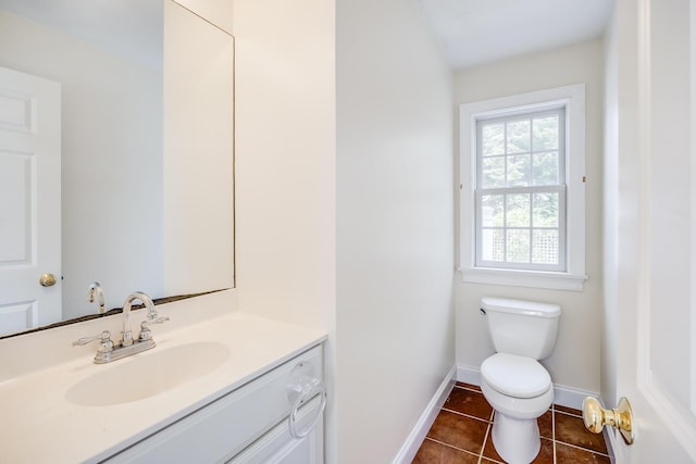 half bath with tile patterned flooring, baseboards, toilet, and vanity