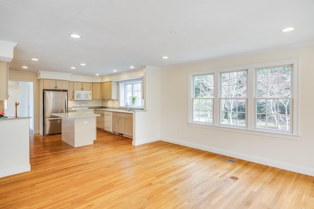 kitchen with white appliances, baseboards, and light wood finished floors