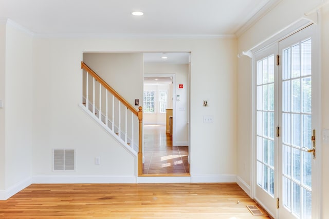 foyer entrance featuring stairway, light wood-type flooring, and visible vents
