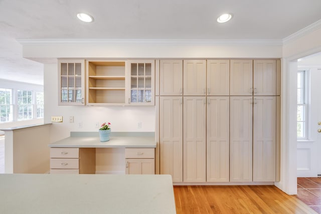 kitchen featuring light wood-style floors, open shelves, light countertops, glass insert cabinets, and ornamental molding