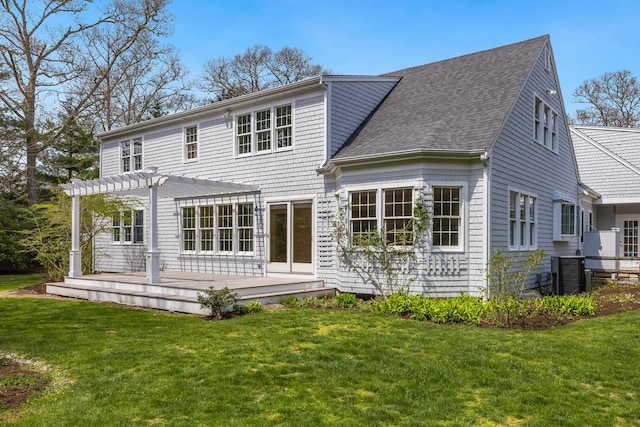 back of property with a pergola, a shingled roof, central AC, a wooden deck, and a lawn