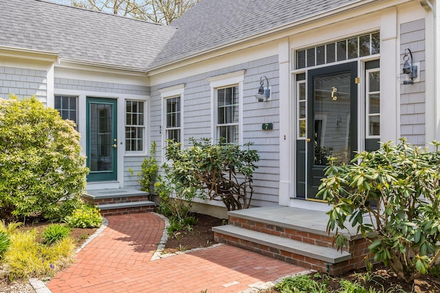 doorway to property with roof with shingles