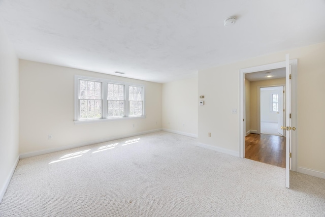 carpeted spare room with baseboards