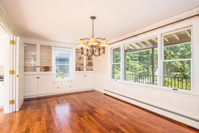 unfurnished dining area with a notable chandelier, crown molding, a baseboard heating unit, built in shelves, and dark hardwood / wood-style floors