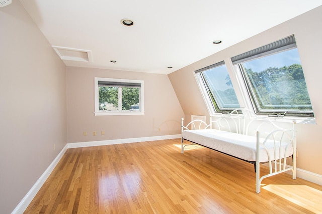 unfurnished room featuring vaulted ceiling and hardwood / wood-style floors