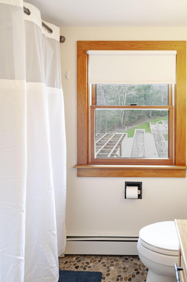 bathroom with toilet, a baseboard radiator, and plenty of natural light