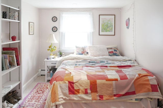 bedroom featuring a baseboard heating unit and light carpet