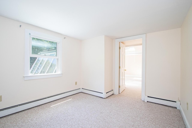 empty room with light colored carpet and a baseboard heating unit