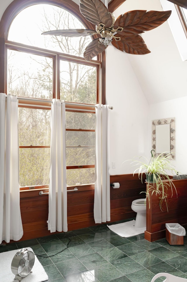 bathroom featuring ceiling fan and vaulted ceiling with skylight