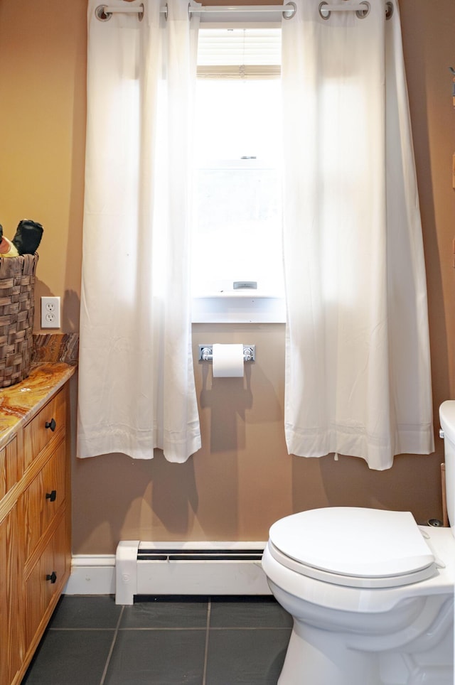 bathroom featuring toilet, baseboard heating, and tile patterned flooring