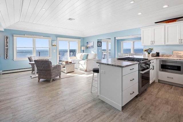 kitchen with a healthy amount of sunlight, high end stainless steel range oven, and wood ceiling