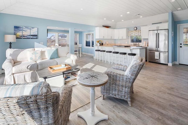 living area featuring recessed lighting, wooden ceiling, light wood-style flooring, and baseboards