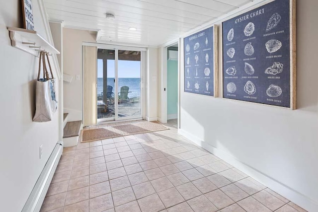 interior space featuring a baseboard radiator, a water view, wood ceiling, baseboards, and tile patterned floors