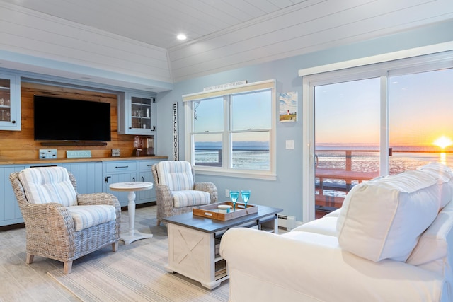 living room with wooden ceiling, recessed lighting, wood walls, a water view, and light wood-style floors