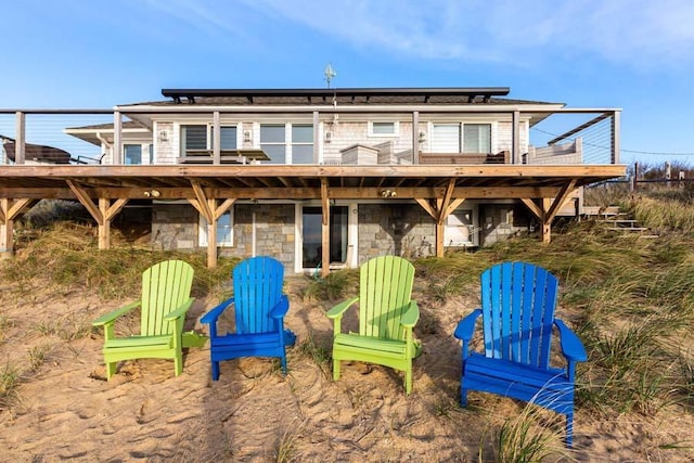 rear view of property with stone siding and a deck