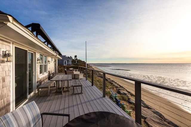 wooden terrace with a view of the beach and a water view