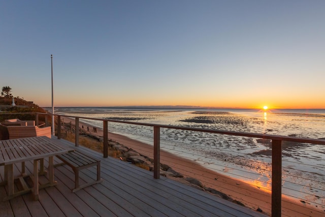 wooden terrace with a view of the beach and a water view