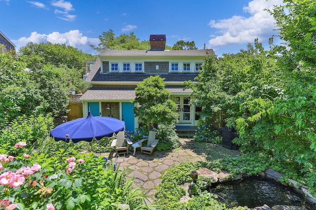 260 Bradford St, Provincetown, MA 02657 - back of property with a chimney, roof with shingles, and a patio