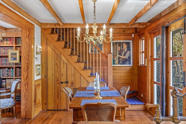 260 Bradford St, Provincetown, MA 02657 - dining area with wooden walls, wood-type flooring, a chandelier, beamed ceiling, and stairway
