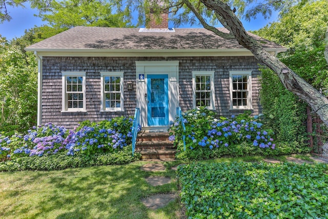 260 Bradford St, Provincetown, MA 02657 - view of front facade featuring a chimney, a shingled roof, and a front yard