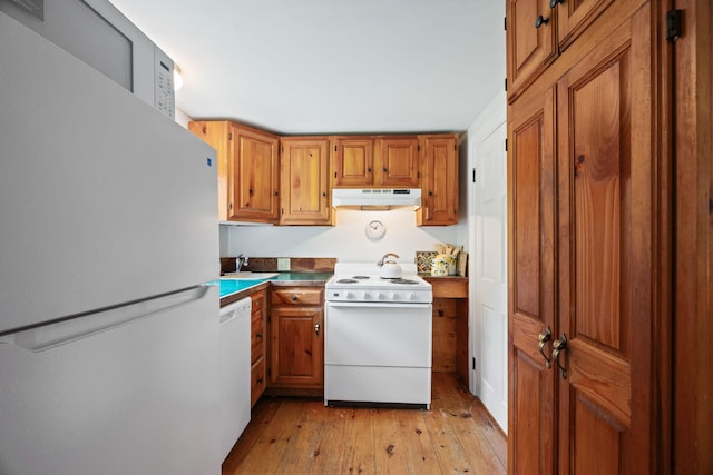 1079 State Hwy Unit 14, Eastham, MA 02642 - kitchen featuring white appliances, under cabinet range hood, light wood finished floors, and brown cabinets