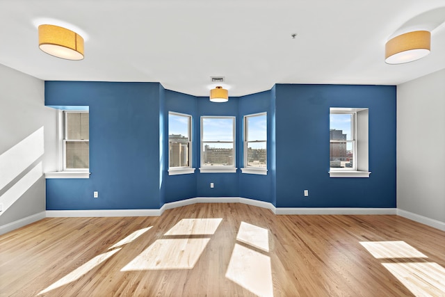 877 Harrison Ave, Boston, MA 02118 - empty room with wood finished floors, visible vents, and baseboards