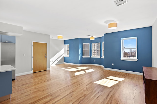 877 Harrison Ave, Boston, MA 02118 - unfurnished living room with baseboards, stairway, visible vents, and light wood-style floors