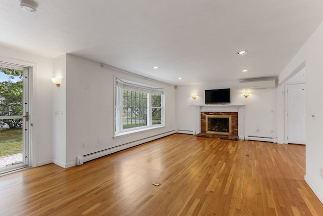 100 Potonumecot Rd, Chatham, MA 02633 - unfurnished living room featuring a baseboard radiator, an AC wall unit, light wood-type flooring, a fireplace, and recessed lighting