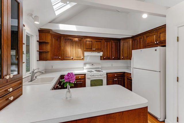 100 Potonumecot Rd, Chatham, MA 02633 - kitchen with white appliances, under cabinet range hood, a sink, vaulted ceiling, and a skylight