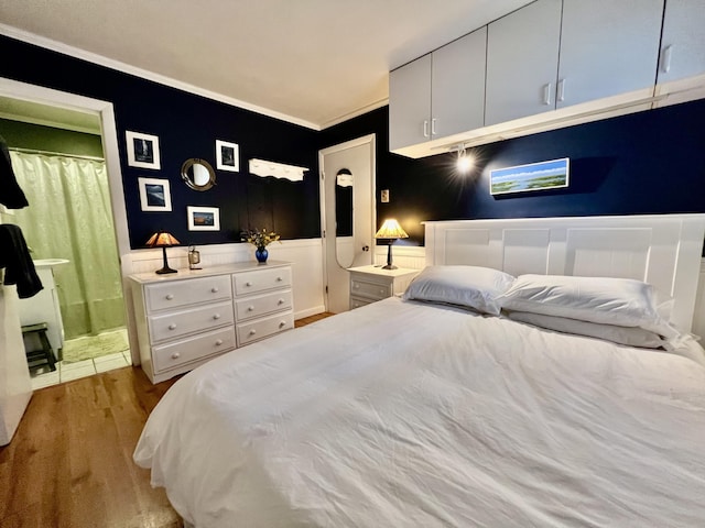 3 Winthrop St Unit U1, Provincetown, MA 02657 - bedroom with wood finished floors, crown molding, ensuite bath, wainscoting, and a fireplace