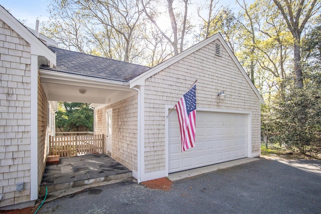 1118 Bumps River Rd, Centerville, MA 02632 - view of side of property with a shingled roof and a detached garage