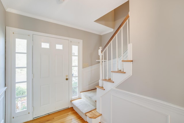 1118 Bumps River Rd, Centerville, MA 02632 - entrance foyer with crown molding, stairs, a wainscoted wall, light wood-style floors, and a decorative wall