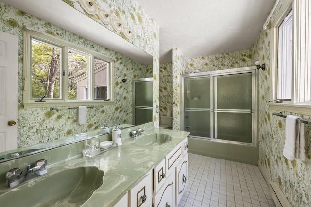 154 Cotuit Bay Dr, Cotuit, MA 02635 - bathroom with wallpapered walls, tile patterned flooring, double vanity, baseboards, and shower / bath combination with glass door