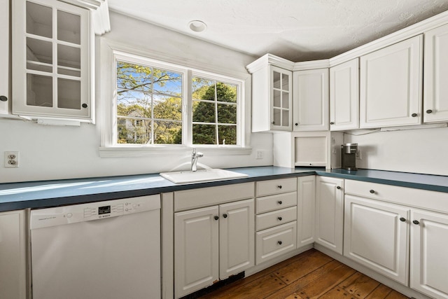 154 Cotuit Bay Dr, Cotuit, MA 02635 - kitchen featuring dishwashing machine, a sink, white cabinetry, dark countertops, and glass insert cabinets