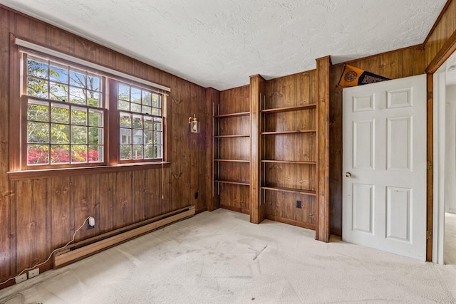 154 Cotuit Bay Dr, Cotuit, MA 02635 - unfurnished room with wood walls, a textured ceiling, a baseboard radiator, and carpet floors