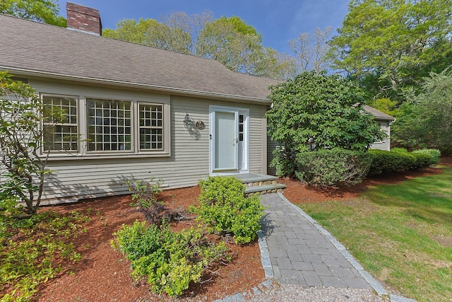 154 Cotuit Bay Dr, Cotuit, MA 02635 - doorway to property with a chimney, a lawn, and a shingled roof