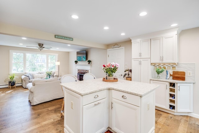 7 Liberty Pl, East Dennis, MA 02641 - kitchen featuring light wood-style flooring, white cabinets, recessed lighting, a center island, and open floor plan