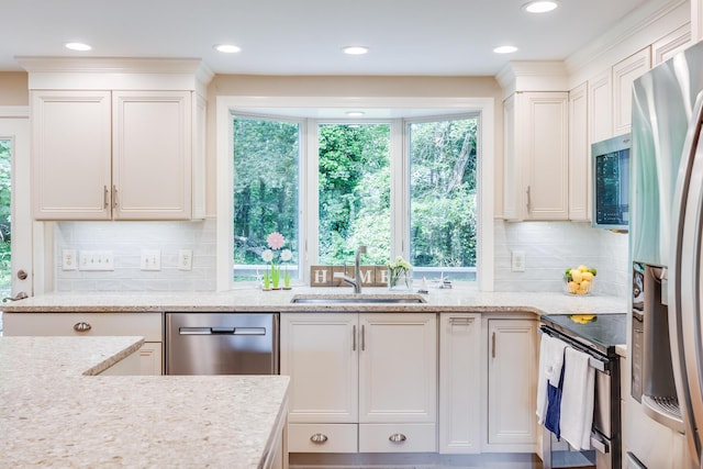 7 Liberty Pl, East Dennis, MA 02641 - kitchen featuring appliances with stainless steel finishes, a sink, light stone countertops, white cabinets, and backsplash
