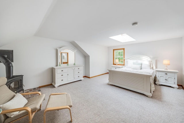 7 Liberty Pl, East Dennis, MA 02641 - bedroom featuring a skylight, a wood stove, baseboards, lofted ceiling, and light carpet