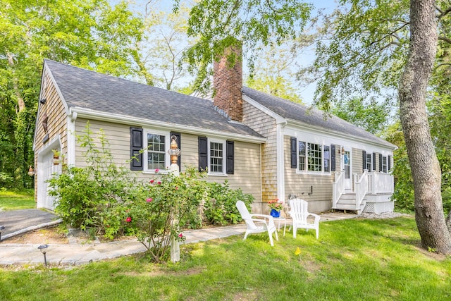 7 Liberty Pl, East Dennis, MA 02641 - view of front of house featuring a chimney, roof with shingles, and a front yard