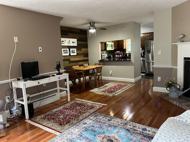 living room with wooden walls, dark hardwood / wood-style floors, and ceiling fan