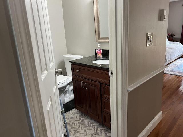 bathroom featuring vanity, toilet, and wood-type flooring