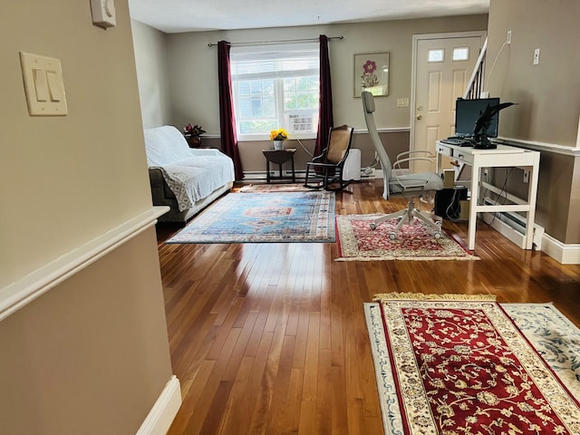 bedroom with hardwood / wood-style floors and a baseboard radiator