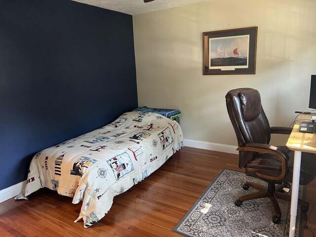 bedroom with dark hardwood / wood-style floors