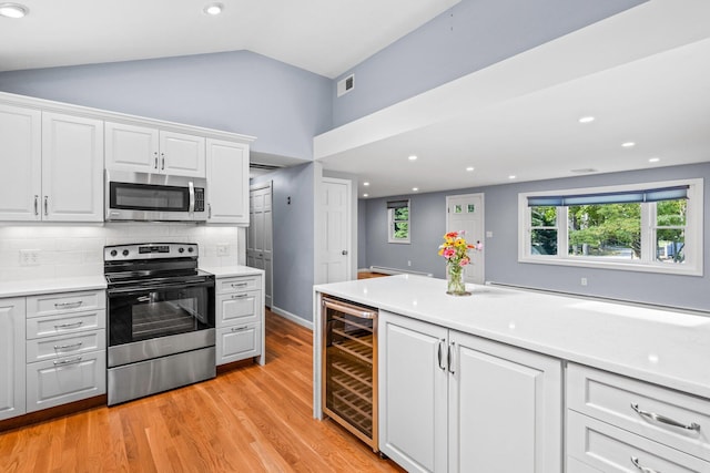 97 Great Western Rd, Harwich, MA 02645 - kitchen with appliances with stainless steel finishes, light wood finished floors, wine cooler, backsplash, and visible vents