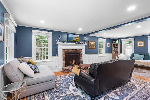 13 Old Fields Rd, Sandwich, MA 02563 - living room with a wainscoted wall, wood finished floors, crown molding, a brick fireplace, and recessed lighting