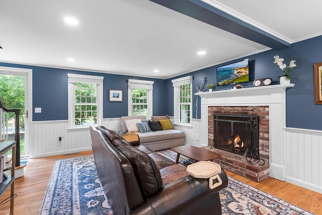 13 Old Fields Rd, Sandwich, MA 02563 - living room with wainscoting, ornamental molding, a fireplace, light wood-type flooring, and healthy amount of natural light