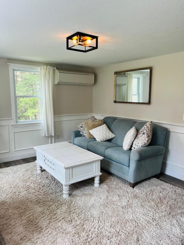 19 Artisan Way, Forestdale, MA 02644 - living area featuring a decorative wall, a wainscoted wall, wood finished floors, a textured ceiling, and a wall mounted AC