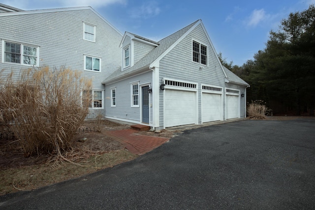 174 Little River Rd, Cotuit, MA 02635 - view of side of home featuring driveway, a shingled roof, and an attached garage
