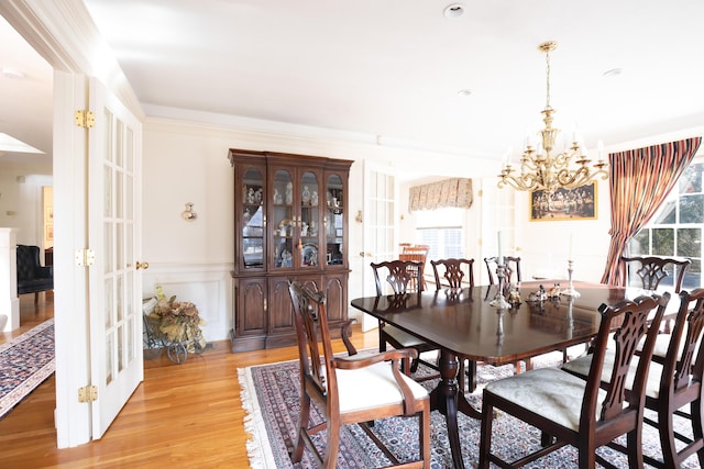 174 Little River Rd, Cotuit, MA 02635 - dining area with a chandelier, plenty of natural light, light wood-style flooring, wainscoting, and ornamental molding